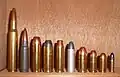 .45 Colt shown alongside other cartridges. From left to right: .30-06, 7.62×39mm, .454 Casull, .45 Colt, .357 Magnum, .38 Special, .45 ACP, 9×19mm Parabellum, .380 ACP, .22 Long Rifle