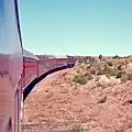 Flash floods regularly washed away bridges and track on the narrow-gauge railway. The Ghan is climbing out of the Finke River depression after track was laid on the river bed as a cheap solution.