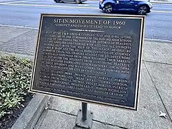 A bronze historical plaque commemorating the Sit-In Movement of 1960 in Chattanooga honors 15 Howard High School students who joined peaceful protests to desegregate lunch counters.