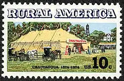 Postage stamp depicting a large canvas tent with three central support poles, and horse-drawn wagons at the front entrance