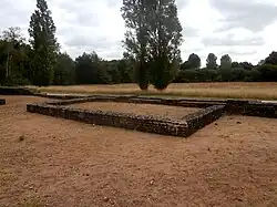 Color photograph of the rectangular masonry base of a structure.