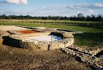 Color photograph of a semicircular wall attached to a flat wall.