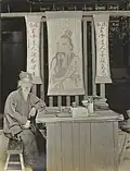 Fortune-teller sitting next to a table, 1908.