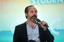 Photograph of Chris Buskirk speaking into a microphone.