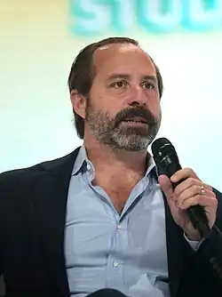 Portrait photograph of Chris Buskirk speaking into a microphone.