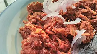 Cochinita pibil is a traditional Mexican slow-roasted pork dish from the Yucatán Peninsula of Mayan origin.