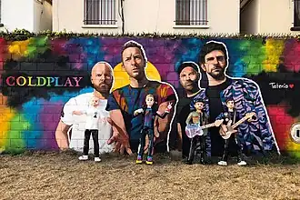Coldplay mural artwork with piñatas of each band member leaning against the wall