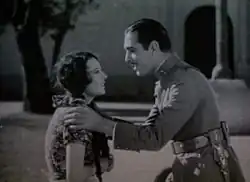 Black and white film still showing a woman and man in 1930s clothing
