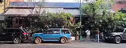 The entry behind multiple parked cars.