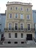 Cream coloured mathematical tiles on an Amon Wilds house at 47 Grand Parade Location on Google Maps
