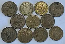 Grouping of brass tokens, most have variations of a woman's head on them