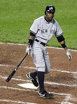Curtis Granderson in a gray New York Yankees uniform, holding a bat below his waist in the batter's box