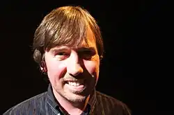 Landscape portrait of a smiling man with light brown hair and short facial hair