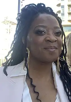 A black woman with earrings looking at the camera.