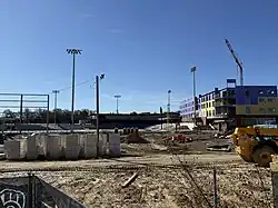 The frame of the stadium with a crane lowering additional beams into place