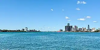 Detroit skyline to the right and Windsor to the left of the Detroit River, with the Ambassador Bridge partially visible in the background from Belle Isle