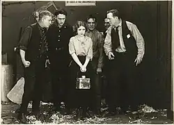 Black and white film still showing actors in period costume