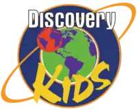 The logo of a Latin American children's TV channel, showing a planet followed by the word "Discovery" in a white font and the word "Kids" in yellow.