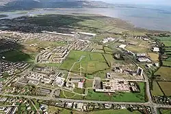 Aerial view of the area with buildings, houses, open lands and on windmill. The Irish Sea is on top right hand corner. There is another island visible on top left hand corner