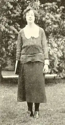 A young white woman with dark hair, standing outdoors