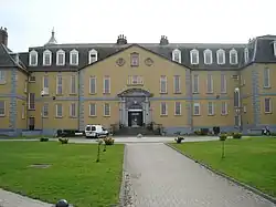 Large yellow three-storey building with tall narrow windows