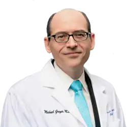 Photograph of Michael Greger in a white coat and brightly colored tie with a transparent background