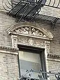 Lunette with dragons on top of a cartouche, and two modillions