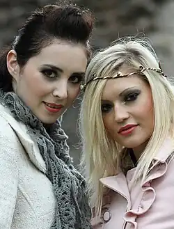 Image 42Two women in England, the woman on the left wears a pompadour, while the woman on the right sports side-parted blonde hair with a boho-style headband, 2011. (from 2010s in fashion)