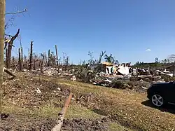 A destroyed home, with the majority of its walls and roof removed.