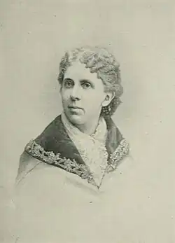 B&W portrait photo of a middle-aged woman with her hair in an up-do.