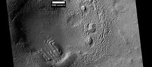 Layered structure in crater that is probably what is left of a layered unit that once covered a much larger area. Material for this unit fell from the sky as ice-coated dust. The picture was taken by HiRISE, under the HiWish program.