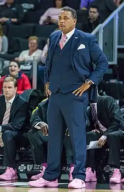 Ed Cooley standing on a basketball court