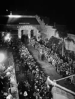 Press photo, a queue of spectators on a gala evening.