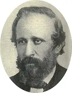photograph portrait of a man with a full beard in a suit and bow tie