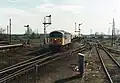 A class 56 heads a northbound aggregates train through Ely station. Note the semaphore signals which were removed during the electrification and resignalling scheme.
