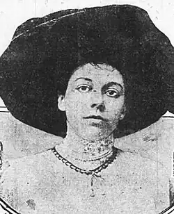 A young white woman wearing a large black hat