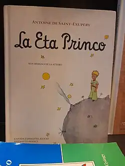 Cover of the Esperanto edition of Antoine de Saint‑Exupéry's The Little Prince, showing the little prince standing on his small planet with stars around him.