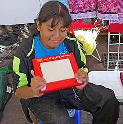 seated girl grasping red box in both hands
