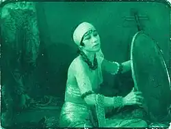 Color still, actress in oriental attire.