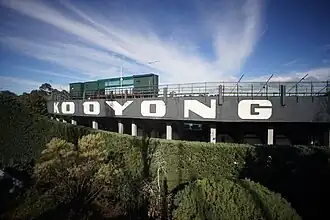 Image of the exterior grandstand (North) of Kooyong tennis stadium in Melbourne Australia showing iconic lettering and broadcast boxes.