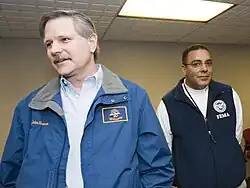 Gov. John Hoeven (2000–2010) wearing a North Dakota State Flag patch on his jacket at a press conference in Fargo