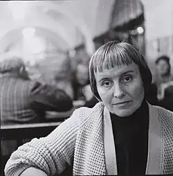 portrait of a middle-aged woman in a white knitted jacket, sitting in a pub