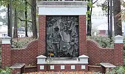 The memorial the end of a pathway featuring a brick monument with a bronze centerpiece