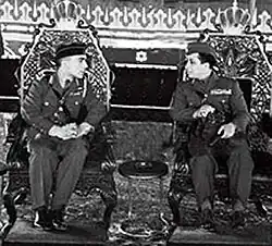 The sovereigns of Iraq and Jordan, in military uniforms, seated in two armchairs
