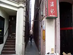 Photograph of an alley with a man walking through it