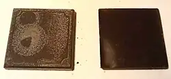 Two squares of chocolate; the left square has a whitish coating