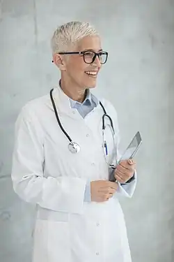 Photo of a female doctor with white hair and glasses