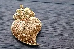 Image 28Typical Portuguese filigree heart shaped pendant, an iconic item in Portuguese fashion and design. (from Culture of Portugal)