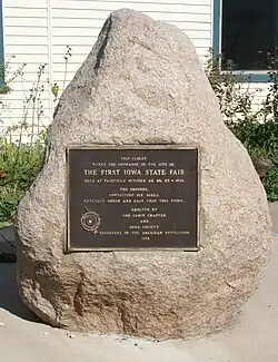 A rock with a plaque in the middle of it commemorating the first Iowa State Fair taken place in Fairfield.
