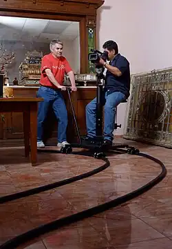 A lightweight riding dolly on flexible track with a seat